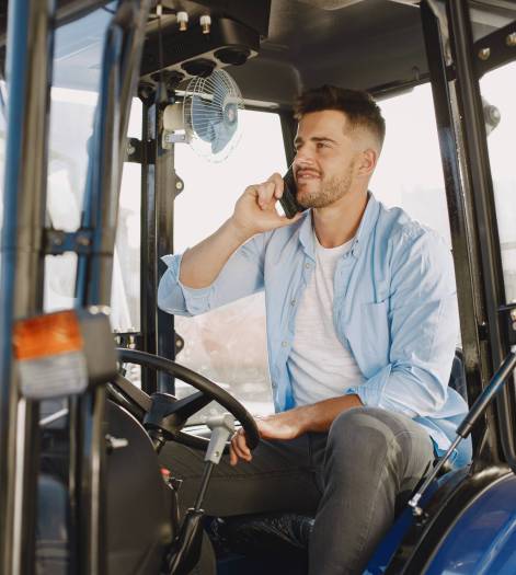Man in a blue shirt. Guy in a tractor. Agricultural machinery.