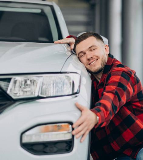young man choosing a car in a car showroom